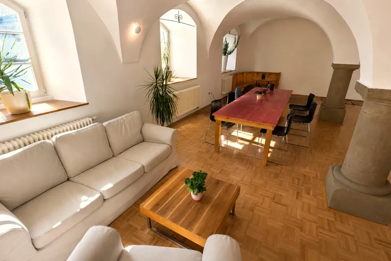 Sofaecke und langer pinker Tisch im Gewölbe vom Traube Coworking in Dinkelsbühl